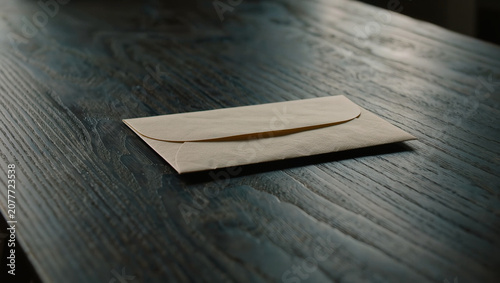 Single Kraft Paper Envelope on Dark Wooden Table - Business, Communication & Mail Concept