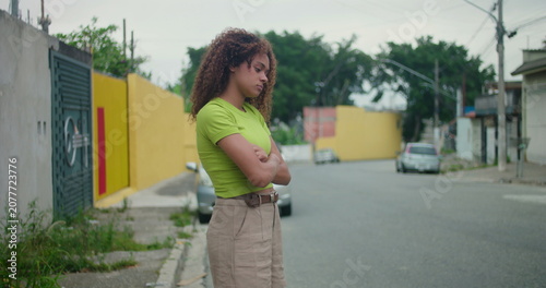 Canvastavla Teenager of African descent standing on a quiet street with arms crossed, displa