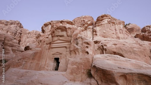 A view of an ancient Nabataean rock cut tomb carved into the sandstone cliffs at the Little Petra archaeological site in Jordan.