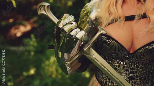 Silhouette Fantasy woman knight in metal armor with weapon iron sword in hands. lady close up body part hand iron glove queen larp ancient warrior old style. fairy elf girl princess. 4k video footage