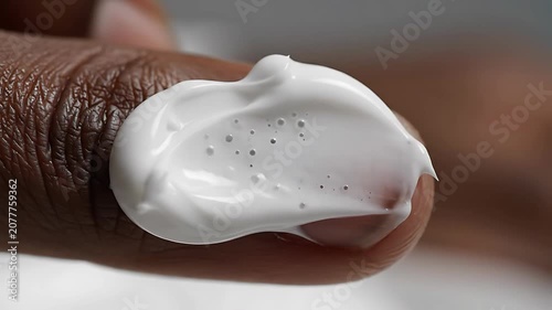 Dark skin finger with white cream.