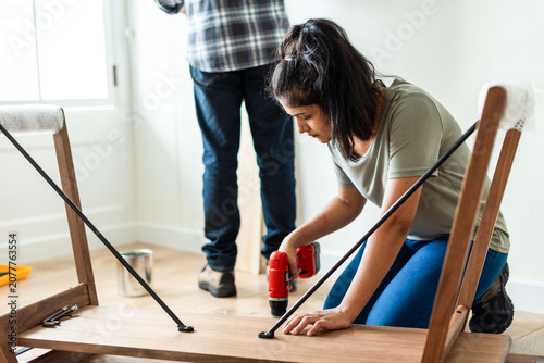 Photography Woman assembling wooden furniture indoors