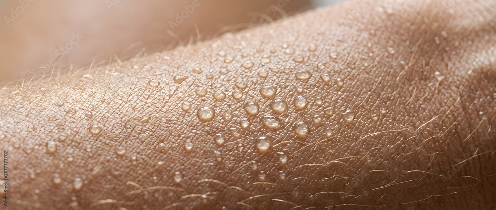 Fototapeta premium Close up of human skin covered in small water droplets on a warm day