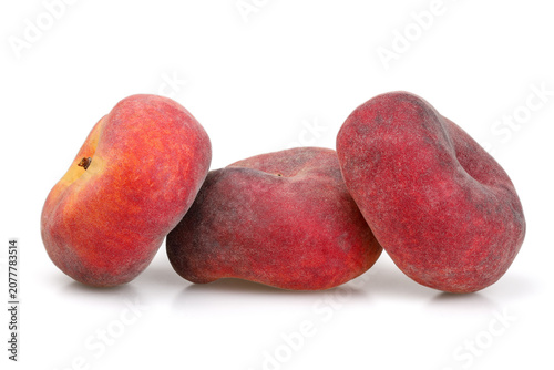 Three fig-shaped peaches on a white background. Flat peaches also have other names—flat peach, saucer peach, peach donut, etc.