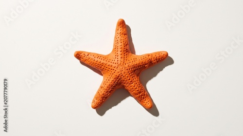 Orange Plasticine Starfish on Ivory White Background