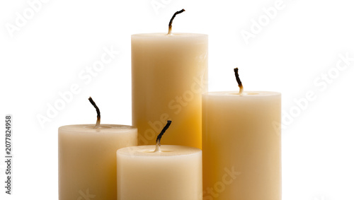 Fotografie Four unlit cream pillar candles with burnt wicks, isolated on transparent backgr