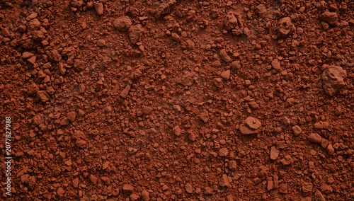 Red clay soil texture background with dry cracked earth pieces