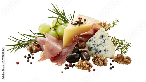 Schilderij op canvas Gourmet cheese platter with prosciutto grapes olives walnuts, and herbs