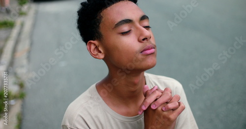 Photography Hispanic teenage boy of African descent looks up with eyes open, smiling in fait