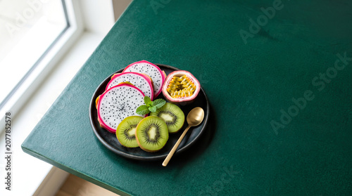 Organic Grocery Flat Lays Tropical Fruit Bowl with Kiwi and Passion Fruit on Green Table