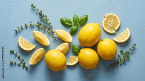 Organic Grocery Flat Lays Fresh Lemons, Lemon Slices and Herbs on Blue Background