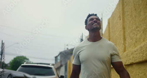 Schilderij op canvas Hispanic Afro-Latin man walking forward along yellow wall, confident and relaxed