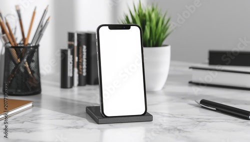 Modern smartphone with blank white screen on charging stand, marble desk in a sunny office workspace, mock-up concept