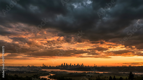Dramatic sunset over a city skyline with a stormy sky