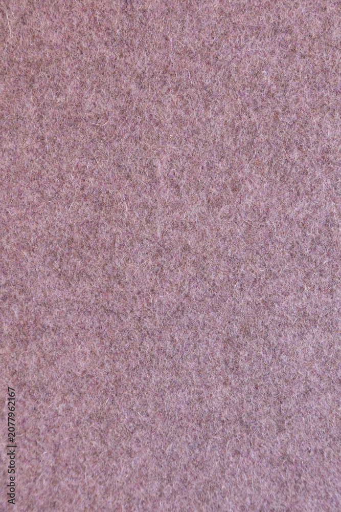 Fototapeta premium Close-up of traditional Portuguese burel wool fabric texture in a soft dusty pink color. The natural felted wool surface displays a dense, uniform fiber structure, making it an ideal seamless