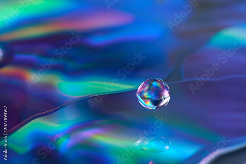 Iridescent water drop on holographic CD surface