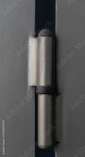 Tableau sur toile Minimalist close-up shot of a metallic door hinge welded onto an industrial gate