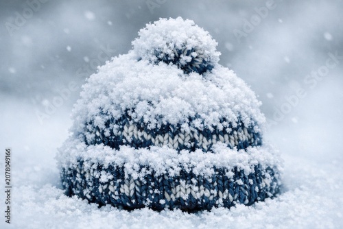 A knitted hat covered in snow on a snowy day, perfect for winter scenes and cold weather photos