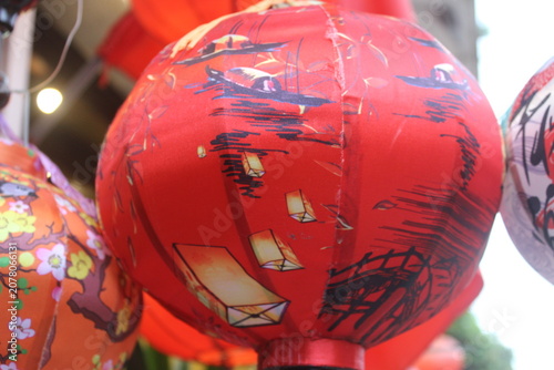 Red lantern decorated with traditional illustrations for festive oriental holiday.