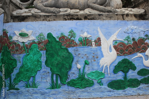 Ornate mural painting depicting blooming lotus flowers and white birds near water.