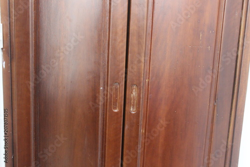 Double wooden wardrobe doors featuring dark polished timber grain and metal handles.