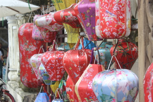 Colorful traditional silk lanterns hanging in rows at a local market in vietnam.
