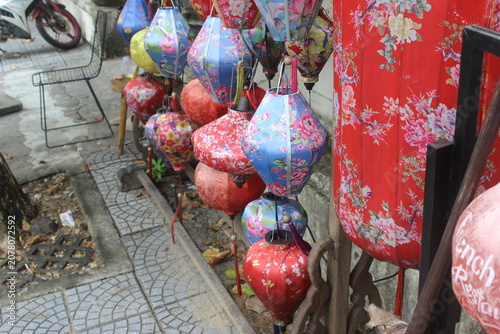 Many silk lanterns hanging in a row at a shop in the streets of hoi an vietnam.