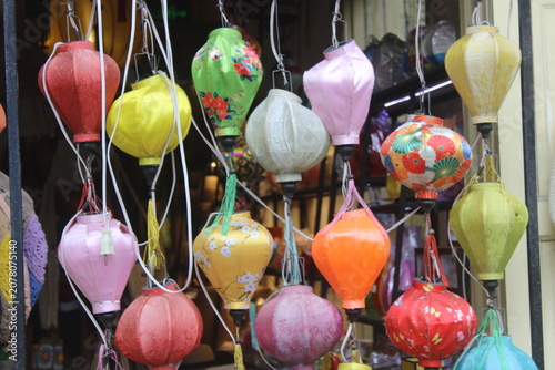 Collection of decorative silk lanterns hanging in store window in ancient vietnam.