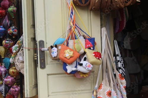 Small colorful crochet purses with cute animal characters for sale at local market.