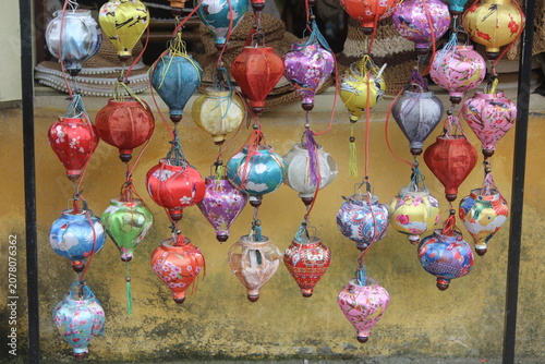 Colorful hanging silk lanterns in Hoi An traditional style street market display.