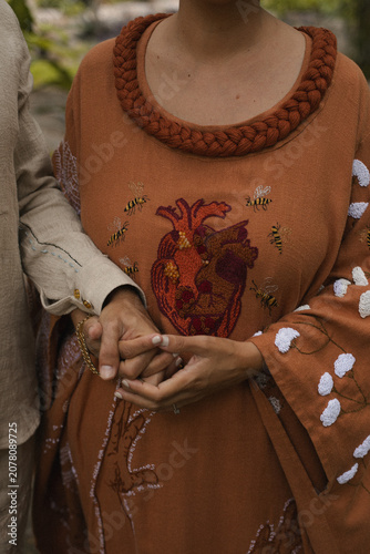 Φωτογραφία pareja tomada de la mano con ropa artesanal