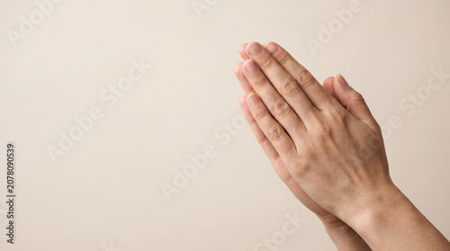 Close up of human hands in prayer position on neutral background for spirituality and peace