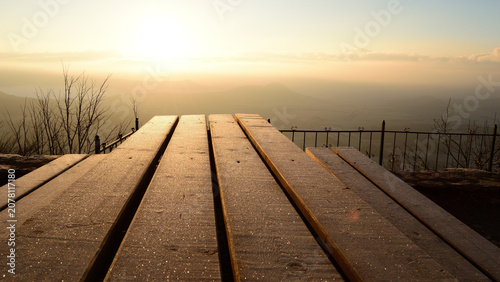 Schilderij op canvas Frosted Wooden Bench at a Mountain Lookout Point overlooking the Morning Mist