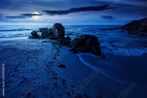Obraz na płótnie huge stones on the sandy beach at night
