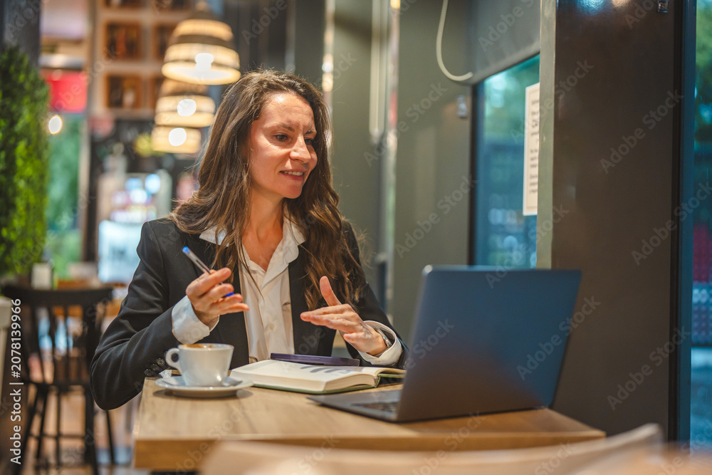 Fototapeta premium Businesswoman having video call meeting in modern cafe