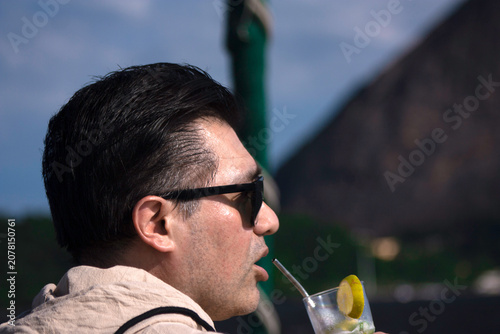 Traveler drinking with sustainable straw lime cocktail by the Sea in Rio de Janeiro Brazil