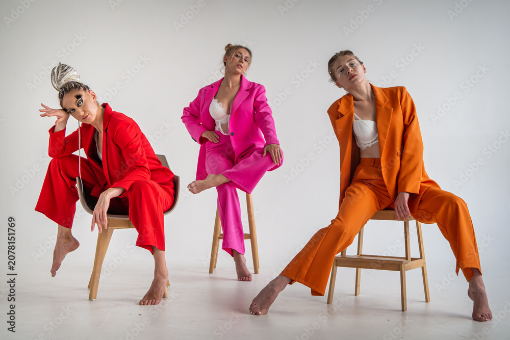 Naklejka premium Adult, sexy girls in white lingerie and bright jackets, posing in a studio against a white background