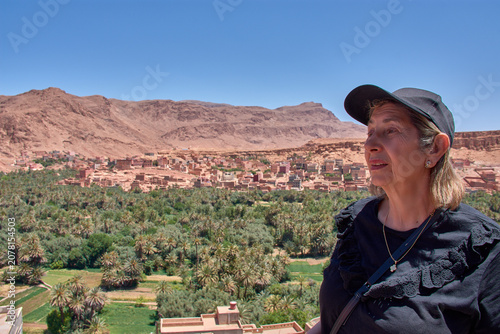 An elderly tourist admires the lush Tinghir oasis and the village of Ait-Boujane in Morocco