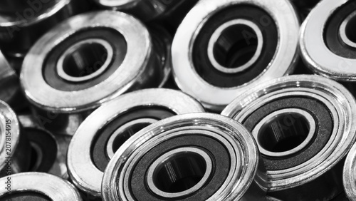 Close-up of numerous ball bearings. Metal surfaces shine brightly. Industrial components for machinery. Precision engineering visible in detail. tech industrial technology background
