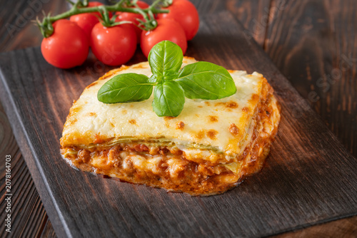 Traditional Lasagna Bolognese Slice Served On Dark Rustic Wooden Board