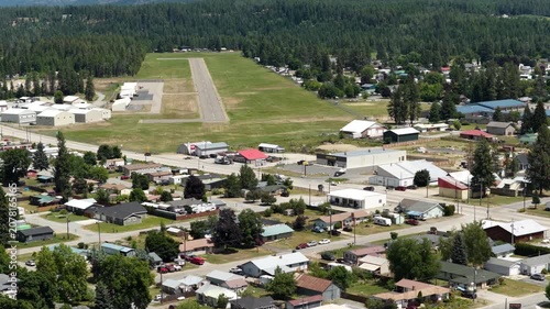 Aerial of small town and airport near Priest River Idaho with residential streets and commercial buildings in summer
