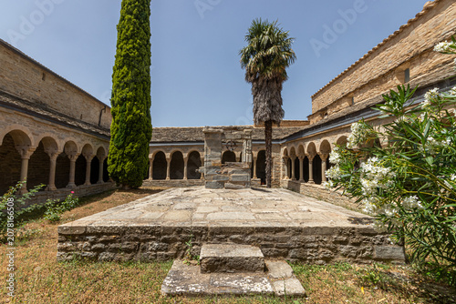 Roda de Isabena, Spain. Romanesque cloister of the Cathedral of San Vicente, 12th century, with a central well dated 1668, round arches on monolithic columns, and Romanesque capitals