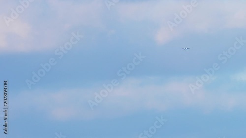 Passenger airplane flying in blue sky with clouds, commercial jet airliner cruising at high altitude, daytime, wide shot
