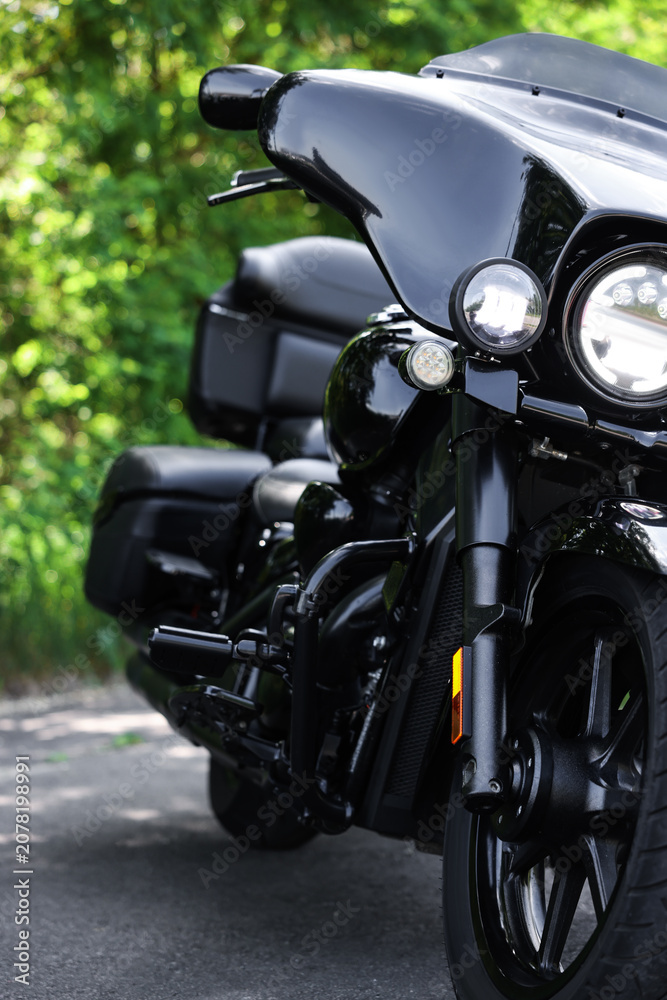 Fototapeta premium Modern black motorcycle parked on road outdoors, closeup
