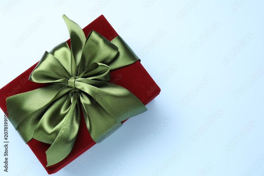 Fototapeta premium Beautiful velvet gift box on light blue background, top view. Space for text