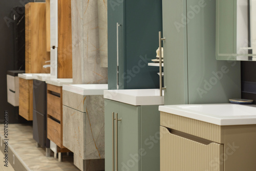 Modern bathroom vanity cabinets and washbasins displayed in a showroom interior. Contemporary bathroom furniture  interior design solutions  home renovation and sanitary ware for retail.