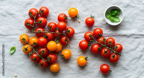 Fresh Cherry Tomatoes on White Surface with Green Basil.