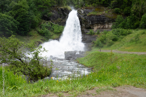 Steinsdalsfossen is a huge waterfall in Norway, making it possible to walk behind the curtain of water