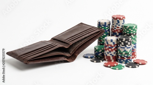 Wallet and Casino Chips: An open brown leather wallet sits next to a colorful stack of casino chips, representing chance, gambling, and financial risk.