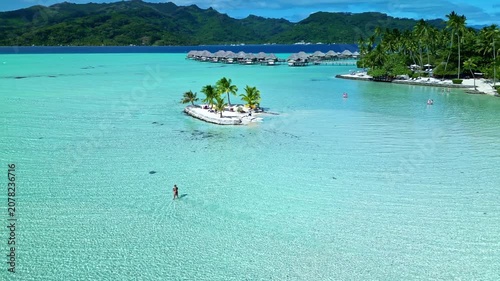 Woman stand up paddle boarding in bora bora lagoon